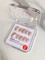 Détail de faux ongles faits main œil de chat rose dans leur boîte de rangement taille S - XS