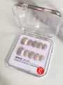 Détail de faux ongles faits main œil-de-chat aux reflets nacrés avec étiquette de taille S - XS / Oolong Pêche Blanche Œil de Chat Court Carré Rond