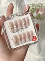 Macro view of handmade press-on nails with gold foil and shell flakes in a clear box - XS / Radio Love Song Medium Coffin