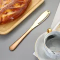 Coltello da burro dorato in acciaio inossidabile con fori per grattugia su un tavolo da colazione - Oro rosa