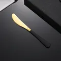 Couteau à beurre moderne en acier doré avec manche noir mat sur fond sombre élégant - Couteau de Table Noir et Or