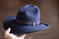 Primer plano detallado del sombrero de fieltro de lana azul oscuro con ala ancha y cinta - Azul oscuro