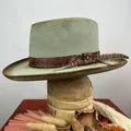Detalle de sombrero de lana con banda de serpiente, cadena de metal y pluma lateral - Verde matcha