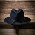 Elegant black wool fedora hat with satin ribbon and bead chain on a vintage wooden stand - Black