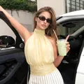 Chic pale yellow halter top with white striped trousers in an urban street setting - S / Yellow
