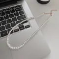 Elegant white pearl necklace with adjustable gold clasp on a laptop keyboard background - Tiny Specification Pearl Style (X1312金5mm)