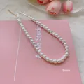 Elegant 8mm white pearl necklace with gold clasp shown on a soft pink decorative book - Medium Specification Pearl Style (X1312金8mm)
