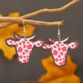 Pink cow print bull head earrings displayed on a natural branch with autumn leaves - Rose Red Pink Cow Print (WEH3922)