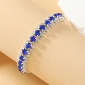 Macro-opname van een luxe bohemien armband met blauwe saffierkristallen en witte strassteentjes - Koningsblauw (Zilveren Basis)