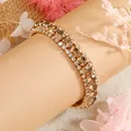 Elegante gouden armband met amberkleurige kristallen en witte strass-accenten - Champagne (KC Goudtint)