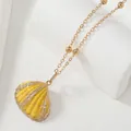 Gros plan du pendentif coquillage jaune avec dorure et collier chaîne à perles - Jaune Or