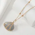 Elegant gold-plated seashell pendant necklace with blue textured finish on white display - Gray & Gold