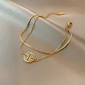 Bracciale a doppio strato dorato con catena a serpente e ciondolo rotondo su seta elegante - Bracciale con Ciondolo Fortuna a Doppio Strato / Oro