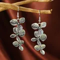 Vista detallada de pendientes asimétricos de flores plateadas con textura de pétalo - Hoja de Pétalo de Triple Capa (WEH4283 Plata Antigua)