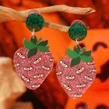 Dettaglio macro di orecchini a fragola surreali in acrilico con design a più occhi - Stile Fragola Grottesca Multi-occhio / Rosa e Rosso