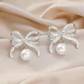 Boucles d'oreilles nœud argentées avec perle blanche et cristal scintillant au centre - Nœud Perle Argent
