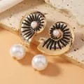 Elegant bow-knot stud earrings featuring black enamel, gold metal, and white pearls - Black Enamel Conch
