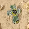 Dettaglio del pendente a croce in smalto verde con motivi a spirale sulla sabbia - Placcato K bianco verde (WR1155)