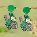 Close-up of Saint Patrick's Day LOVE acrylic earrings hanging on a natural wooden branch - LOVE Gnome (WEH5927)