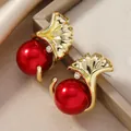 Dettaglio di orecchini a foglia di ginkgo dorati con perle rosse e strass scintillanti - Stile Perla Rossa a Foglia di Ginkgo (WEH4989)