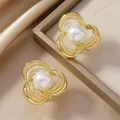 Dettaglio degli orecchini a fiore dorati con perle su elegante sfondo di raso - Stile Perla a Foglia d'Oro (WEH4961)