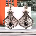 Detail view of vintage fan-shaped tulip earrings with grey rhinestones and black gem - Bright Black Antique KC Gold