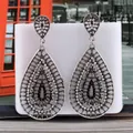 Macro view of vintage silver fan-shaped tassel earrings with black and white rhinestones - White Black Antique Silver