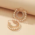 Close-up of gold plated hoop earrings with hollow metal patterns and white pearls - Gold Hollow Artificial Pearl Rhinestone Hoop (WEH1929)