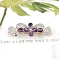 Elegant gold flower hair clip featuring purple marquise crystals and white rhinestones - Cross Knot Purple