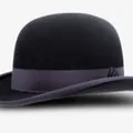 Classic black wool bowler hat with a round dome and decorative ribbon on a white background - Black