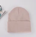 Texture de maille détaillée du bonnet rose clair à revers avec accessoires lifestyle - Poche zippée