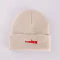 Detalle de bordado de ballena roja en gorro beige que muestra textura suave - M / Caqui