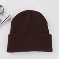 Detailed close-up of dark brown knit beanie texture with folded edge for winter warmth - Coffee