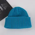 Close-up of thick ribbed knit texture on a peacock blue beanie with folded brim - Adult / Lake Blue