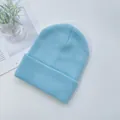 Détail du bonnet en maille côtelée bleu clair avec large revers sur fond blanc épuré - Bleu ciel