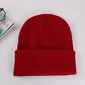 Detailed knit texture of solid red cuffed beanie hat on a clean white background - Burgundy