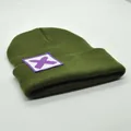 Detailansicht der Rippstrick-Textur und des lila X-Logo-Patches auf der grünen Mütze - X-Symbol-Stil (S3V2-ArmyGreen-X)