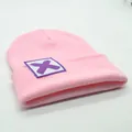 Detail der rosa Strickmütze mit quadratischem weißem Aufnäher und lila X-Grafikmuster - X-Symbol-Stil (S3V2-Pink-X)