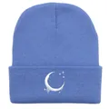 Dettaglio del berretto in maglia azzurro con ricamo bianco di luna e stelle - Blu ciano