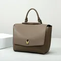 Bolso de mano minimalista de cuero topo con asa única y elegante cierre de perla dorada - Caqui
