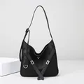 Minimalist black leather hobo bag with silver buckle straps and adjustable shoulder strap - Black