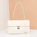 Detail view of cream rectangle shoulder bag with matte leather finish and metal push lock - Beige