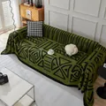 Olive green velvet sofa cover with black geometric patterns in a cozy living room setup - Green