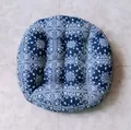 Macro view of blue paisley round cushion showing button tufting and thick cotton texture - Pattern-3