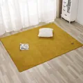 Detail of a mustard yellow plush rug featuring a brown leather label on light wood flooring - 70x180cm / Yellow