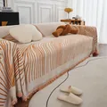 Chenille sofa cover with abstract orange waves and tassels in a cozy home setting - 180x150 / Line Orange