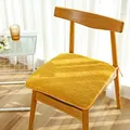 Dickes ingwergelbes Plüsch-Sitzkissen mit Bändern auf einem Holzstuhl im Sonnenlicht - Quadratischer Stil / Gelb