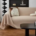 Funda de sofá tipo gofre blanco crema con borlas en un salón de estilo moderno - 180x90cm / Caqui