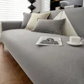 Housse de canapé gris gaufré avec coussins assortis sur un canapé en cuir blanc - 70x70cm / Gris clair