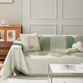 Copridivano in ciniglia verde salvia con motivi geometrici, nappe e cuscino d'arte - Serie Seya / 180*90 / Verde